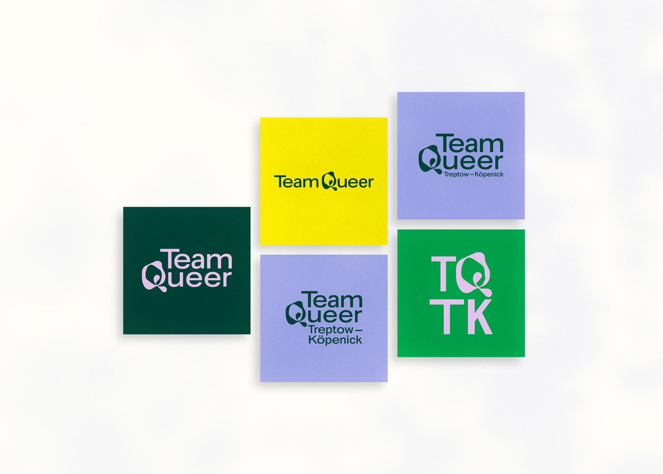 Fünf bunte quadratische Karten liegen auf hellgrauen Hintergrund. Sie zeigen die verschiedenen Logovarianten des Team Queer Treptow-Köpenick. Die Farben des Projekts sind: Dunkelgrün, Gelb, hell-grau-Violet, Knallgrün und Rosa.