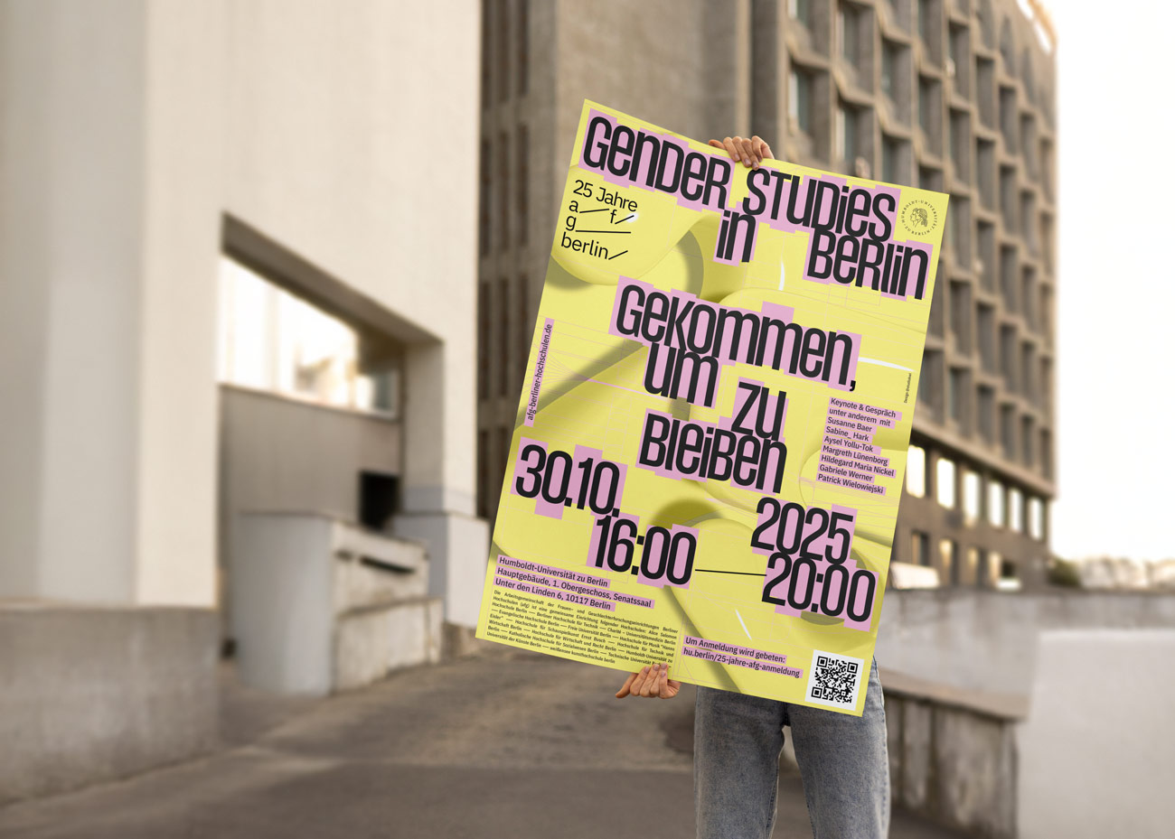 Person hält Plakat mit Text 'Gender Studies in Berlin gekommen, um zu bleiben 30.10. 16:00 2025 20:00' vor einem Gebäude