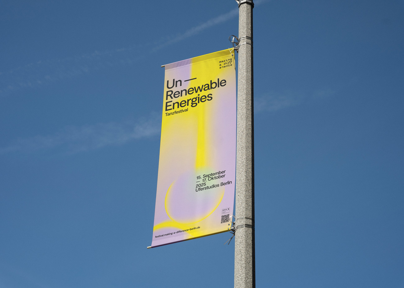 Banner mit Text 'Un Renewable Energies Tanzfestival', darunter Termine '25. September bis 17. Oktober 2023' und Veranstaltungsort 'Universitätsstudios Berlin' an einem grauem Mast vor blauem Himmel