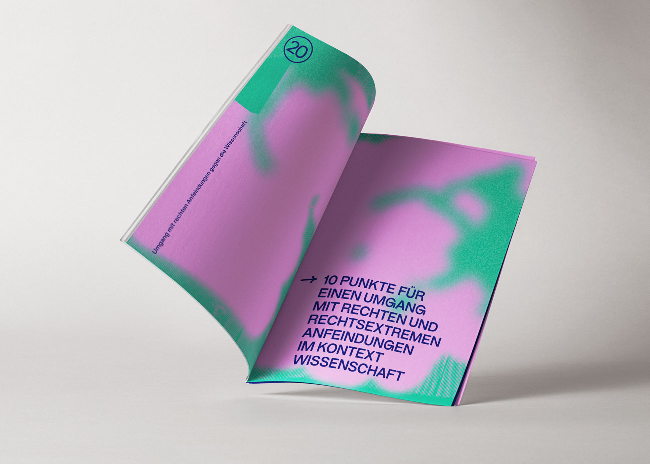 Geöffnetes Buch mit einer Doppelseite, die einen pinken Hintergrund mit grünen, wolkenartigen Farbverläufen zeigt. Auf der rechten Seite steht in dunkelblauer, serifenloser Schrift der Text: '10 PUNKTE FÜR EINEN UMGANG MIT RECHTEN und RECHTSEXTREMEN ANFEINDUNGEN IM KONTEXT WISSENSCHAFT'. Die linke Seite enthält am oberen Rand die Zahl '20' in einem Kreis und einen senkrecht verlaufenden Text am linken Rand. Das Buch liegt auf einer hellen, neutralen Oberfläche.