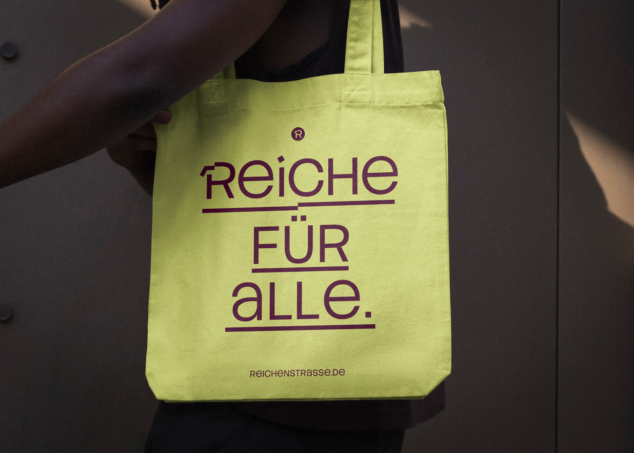 Eine PErson trägt einen gelben Beutel mit der Aufschrift Reiche für alle.